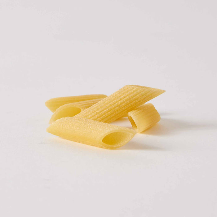 A blue and white bag of ATALANTA CORPORATION CIPRIANI - ORGANIC DURUM WHEAT PENNE PASTA stands upright against a plain white background, with a clear window showing organic penne inside.