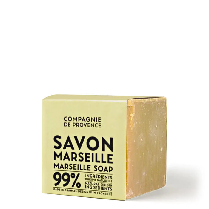 A beige package labeled "COMPAGNIE DE PROVENCE - AUTHENTIC CUBE OF SOAP FRAGRANCE FREE 13.8OZ" by CIE LUXE BRANDS contains a visible block of natural Marseille soap made with vegetable oils.