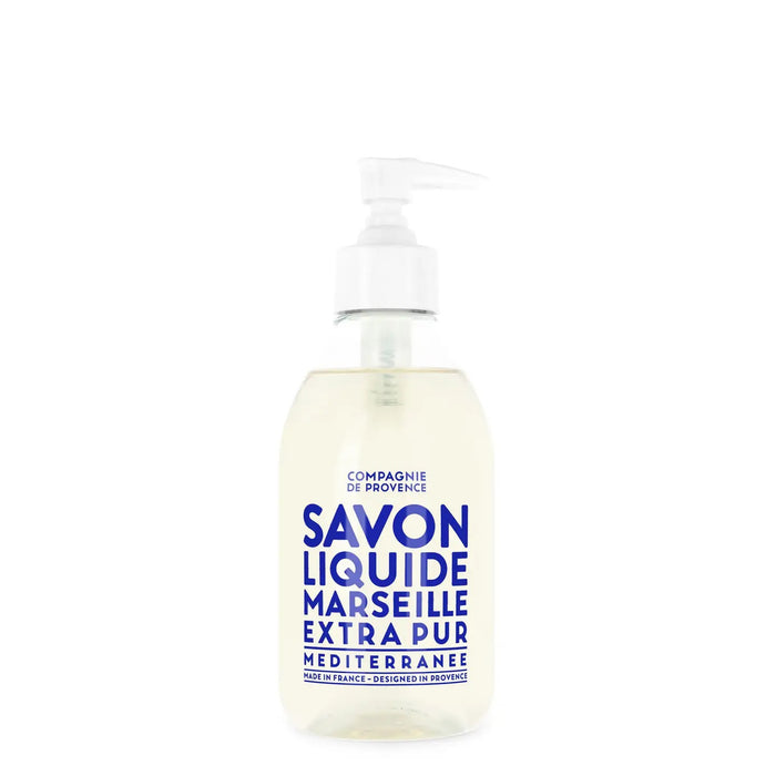 A clear pump bottle of CIE LUXE BRANDS’ COMPAGNIE DE PROVENCE SAVON LIQUIDE DE MARSEILLE MEDITERRANEAN SEA 10OZ features nourishing botanical oils and a white label with bold blue text.