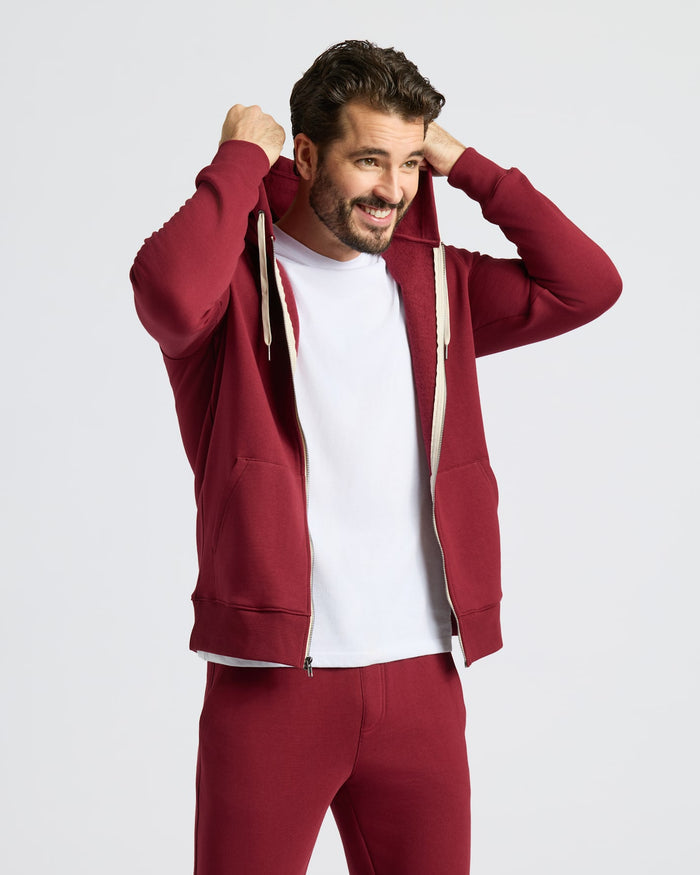Man wearing Dark Maroon Fleece French Terry Zip Hoodie, smiling.
