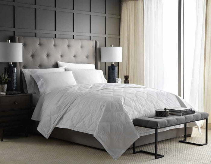 The FEARRINGTON LIFESTYLE BEDDING COLLECTION - SMARTDOWN LIGHTWEIGHT FEATHER MIX BLANKET by DOWNLITE, featuring a subtle diamond-stitched pattern, is neatly folded and perfect for summer use, shown on a plain white background.