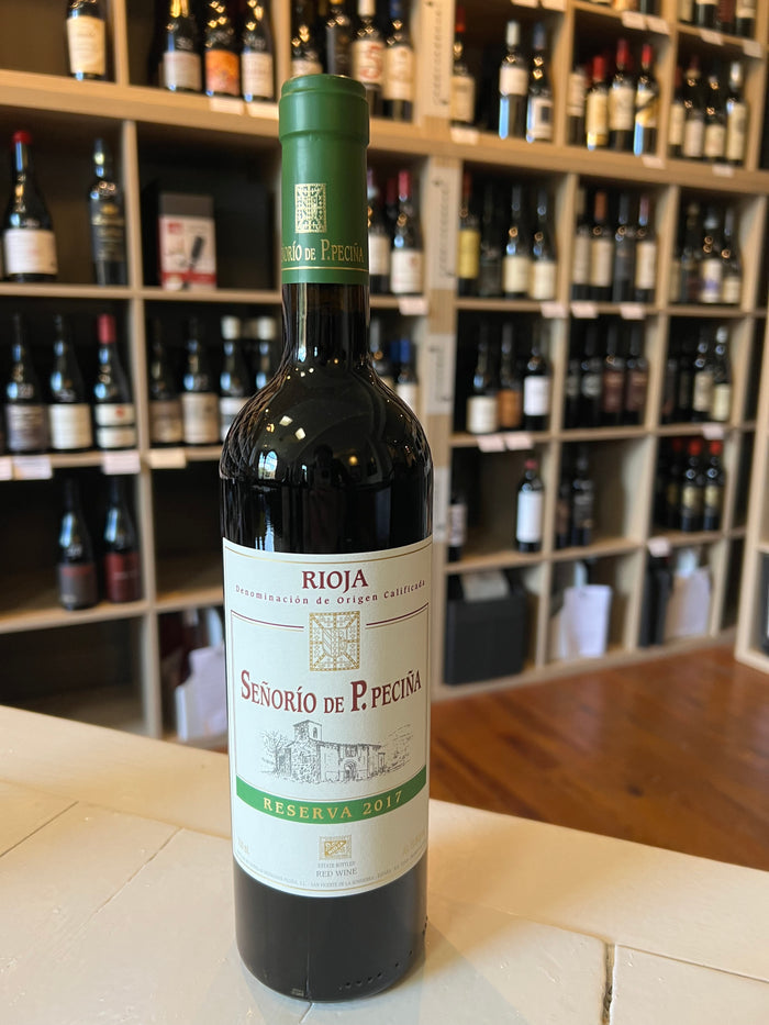 A bottle of PECINA RIOJA RESERVA 2017 by WINE: ADVINTAGE with a cream and green vineyard-illustrated label, shown on a plain white background.