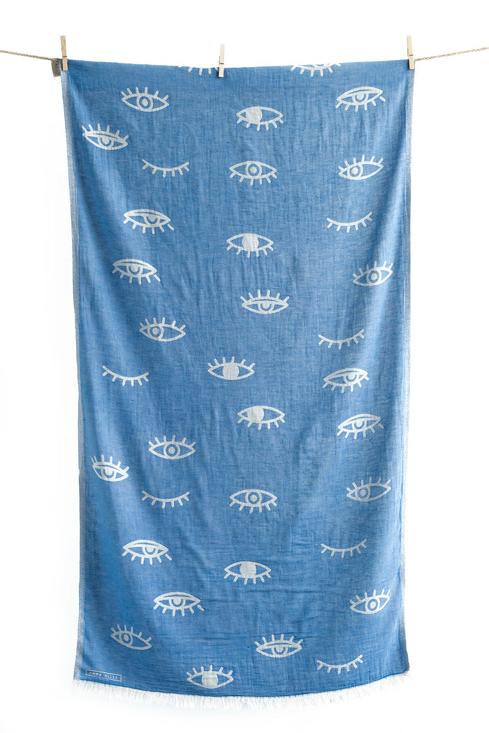 Cotton blue pestemal towel with white eye pattern hanging on a clothesline