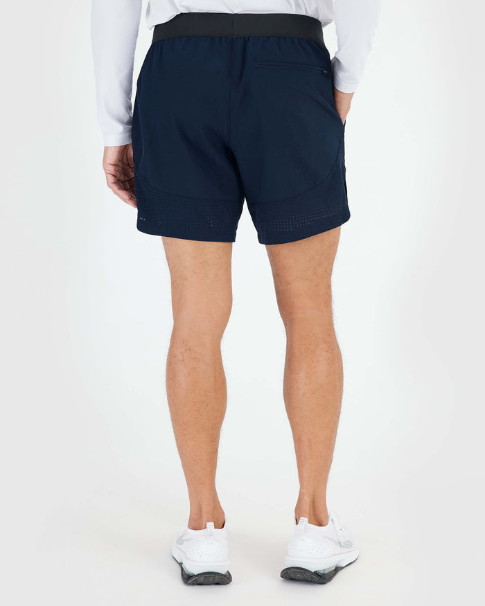 7 Navy Active Training Short with zip pocket and perforated hem worn by model.