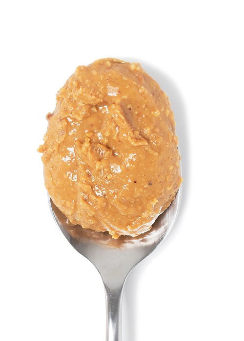 A jar of BIG SPOON ROASTERS - PECAN PEANUT WILDFLOWER HONEY NUT BUTTER features wildflower honey, organic coconut oil, and sea salt. The gold lid and white label display the BIG SPOON ROASTERS brand and product details.