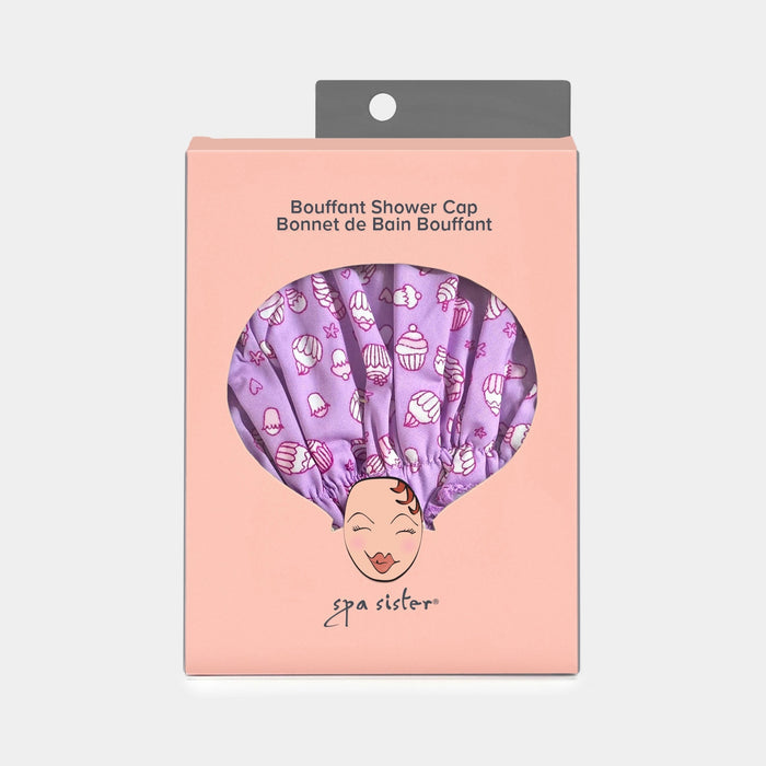 The BOUFFANT SHOWER CAP - CUPCAKES by BATH ACCESSORIES COMPANY features a pink waterproof design with a playful cupcake pattern on a light background.