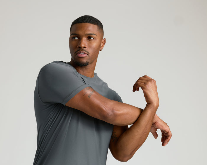 Carbon Tall Active Crew Neck 2.0 worn by man stretching arms.