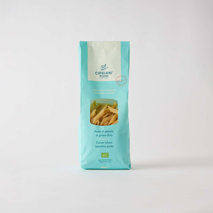 A blue and white bag of ATALANTA CORPORATION CIPRIANI - ORGANIC DURUM WHEAT PENNE PASTA stands upright against a plain white background, with a clear window showing organic penne inside.