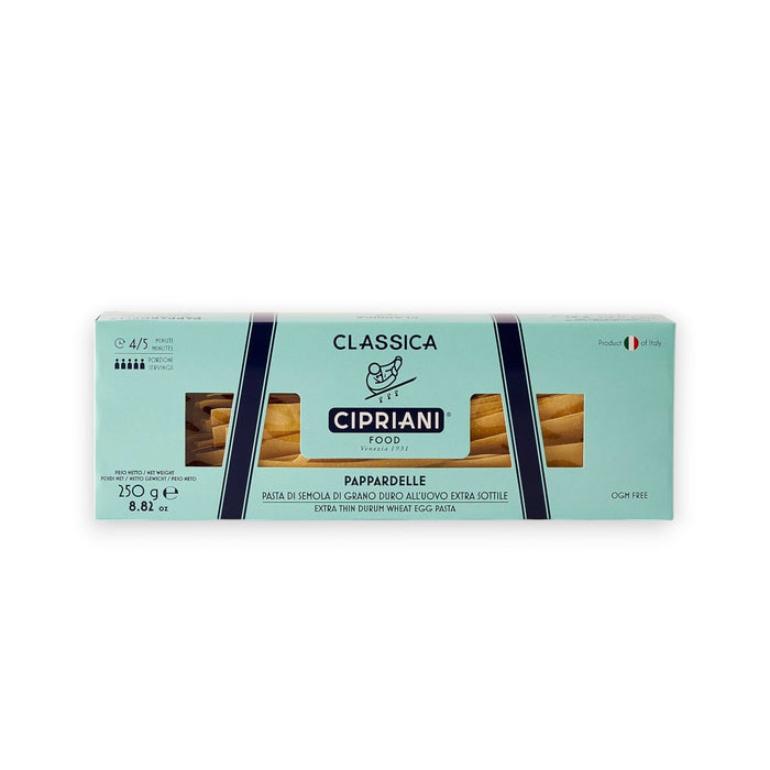 A rectangular box of Cipriani Organic Egg Pappardelle Pasta, produced by Atalanta Corporation and made in Italy, is displayed against a pale background. The light blue packaging with dark blue and white accents features branding details, cooking information, and a small Italian flag denoting its origin.