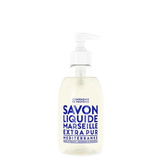 A clear pump bottle of CIE LUXE BRANDS’ COMPAGNIE DE PROVENCE SAVON LIQUIDE DE MARSEILLE MEDITERRANEAN SEA 10OZ features nourishing botanical oils and a white label with bold blue text.
