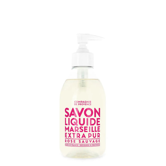 The COMPAGNIE DE PROVENCE - SAVON LIQUIDE DE MARSEILLE WILD ROSE SOAP 10OZ by CIE LUXE BRANDS comes in a clear pump bottle with bold pink text and offers an elegant wild rose fragrance.
