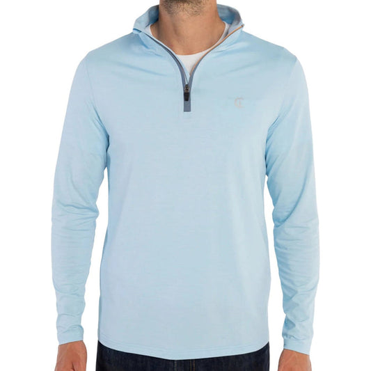 A man wears the CRIQUET Feather Performance Knit Quarter Zip Pullover in Heather Blue, featuring brrr° technology and a small embroidered logo on the chest, over a white T-shirt. His face is partially out of frame.