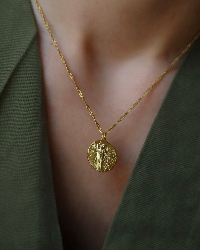 Woman wearing gold-plated round pendant necklace with Greek Goddess Demeter. Greek mythology jewelry made in Greece