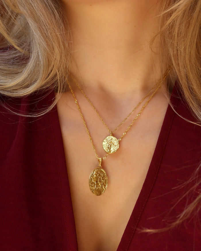 Woman wearing gold pendant necklaces with Greek Goddess Demeter and Persephone; Greek mythology jewelry made in Greece