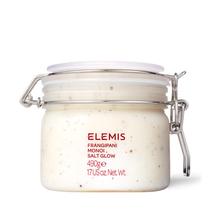 A clear glass jar with latch lid contains white ELEMIS – FRANGIPANI MONOI SALT GLOW by ELEMIS – STEINER. The label features red text, product name, 490g/17 US oz net weight—an indulgent exfoliating scrub for smooth, radiant skin.