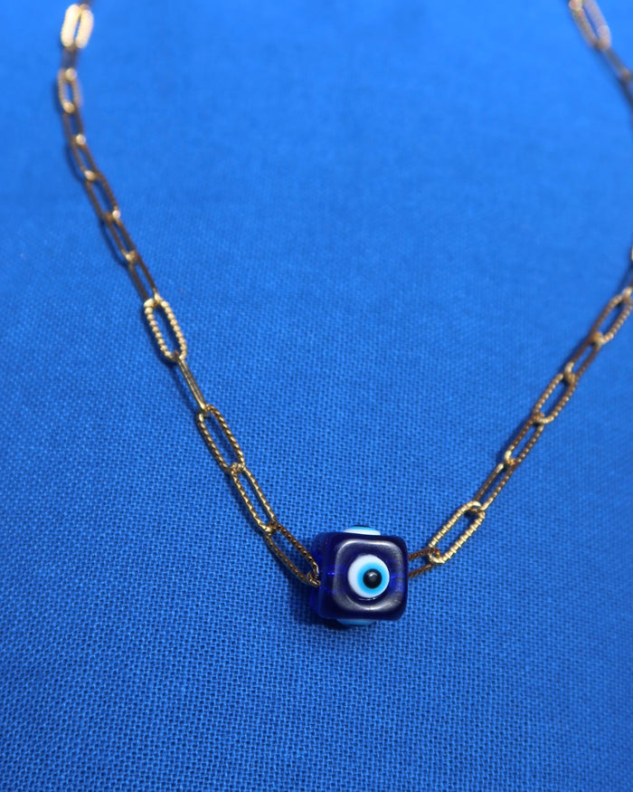 Necklace with a blue evil eye cube charm pendant on a gold paperclip chain made in Greece; Greek evil eye jewelry