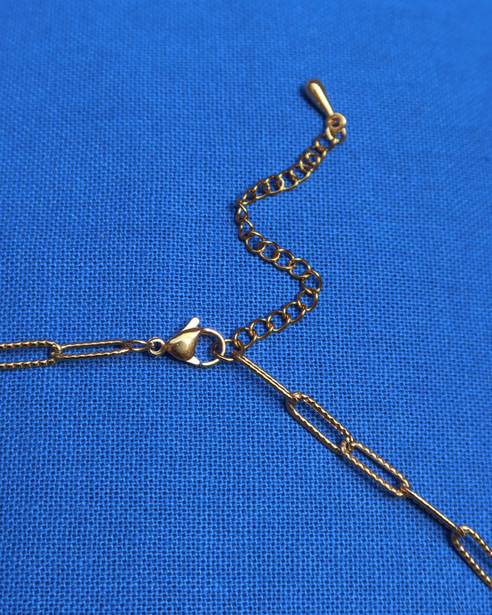 Extender and lobster claw clasp of a gold paperclip link chain necklace