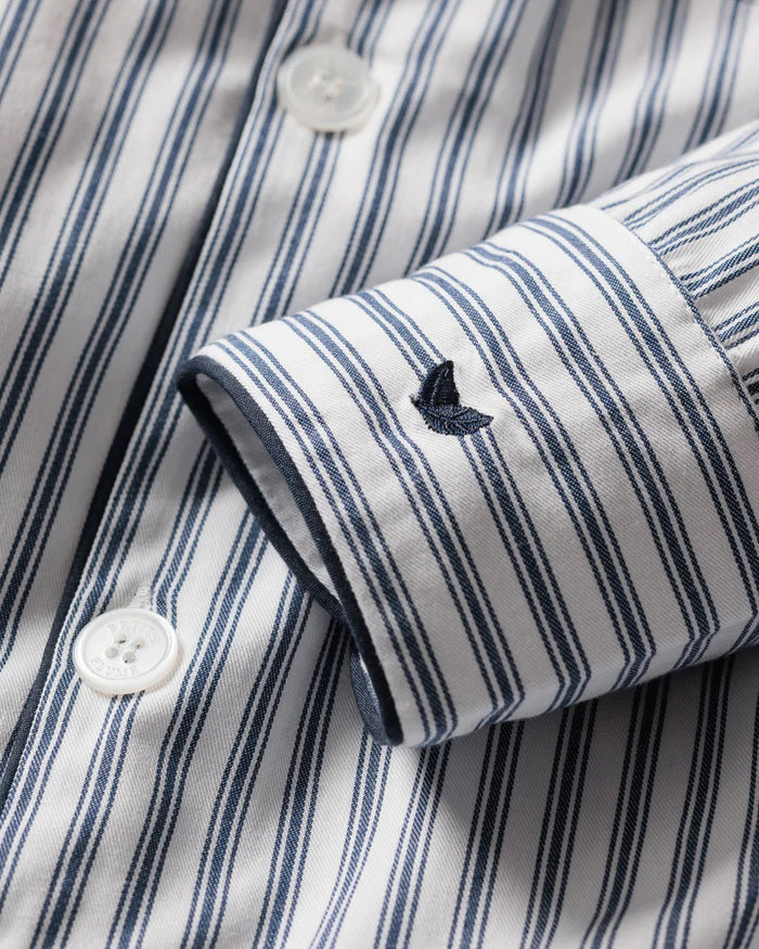 The PETITE PLUME FEARRINGTON LIFESTYLE COLLECTION - CHILDREN'S TWILL NAVY FRENCH TICKING PAJAMA SET is a delightful option for kids, featuring long sleeves and pants with chic vertical white and gray stripes. This set is crafted from yarn-dyed cotton, boasting a top with a collar, full button-down front, and a single chest pocket adorned with matching fabric piping along the cuffs and pocket opening.