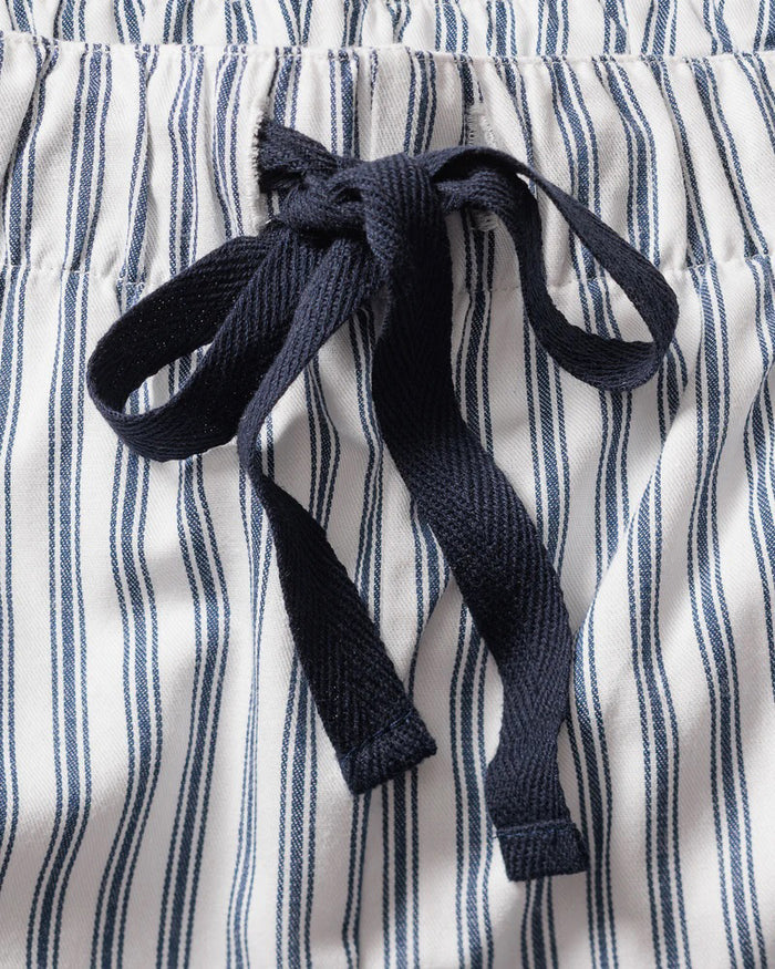 The folded FEARRINGTON LIFESTYLE COLLECTION - MENS TWILL NAVY FRENCH TICKING PAJAMAS by PETITE PLUME features luxury cotton sleepwear in white with navy stripes, a chest pocket with embroidered sheep, and a “Petite Plume” tag on the collar.
