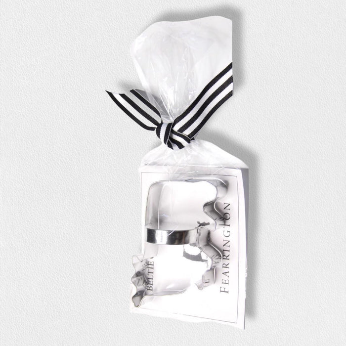 The FEARRINGTON SIGNATURE COLLECTION - BELTIE COOKIE CUTTER by AD RESOURCES is a metal Beltie-shaped cookie cutter in a clear bag, tied with a black-and-white striped ribbon, and includes a recipe card and "FEARINGTON" labeled card.