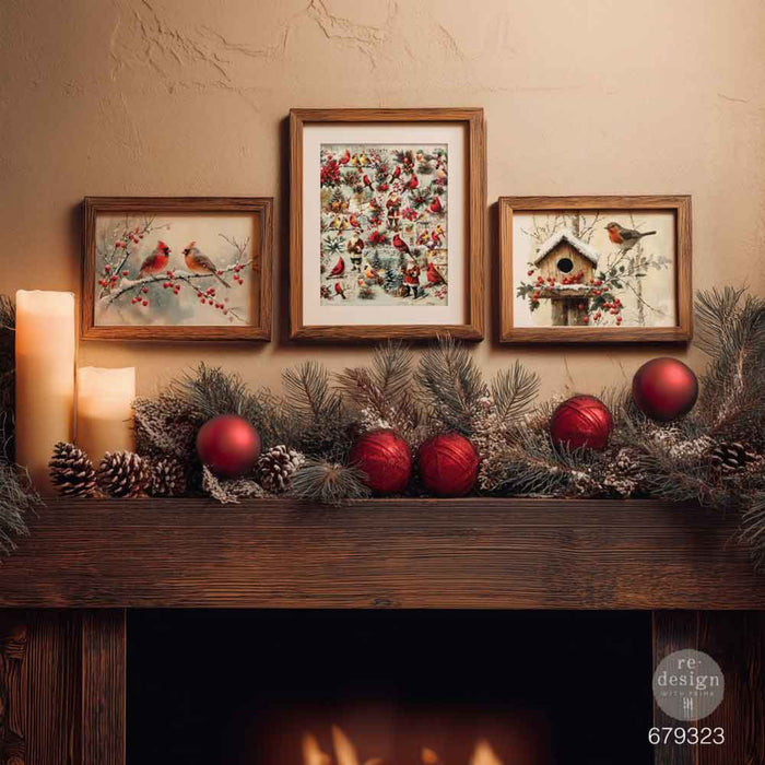 Decorative mantel with framed artwork and Christmas ornaments against a beige wall.