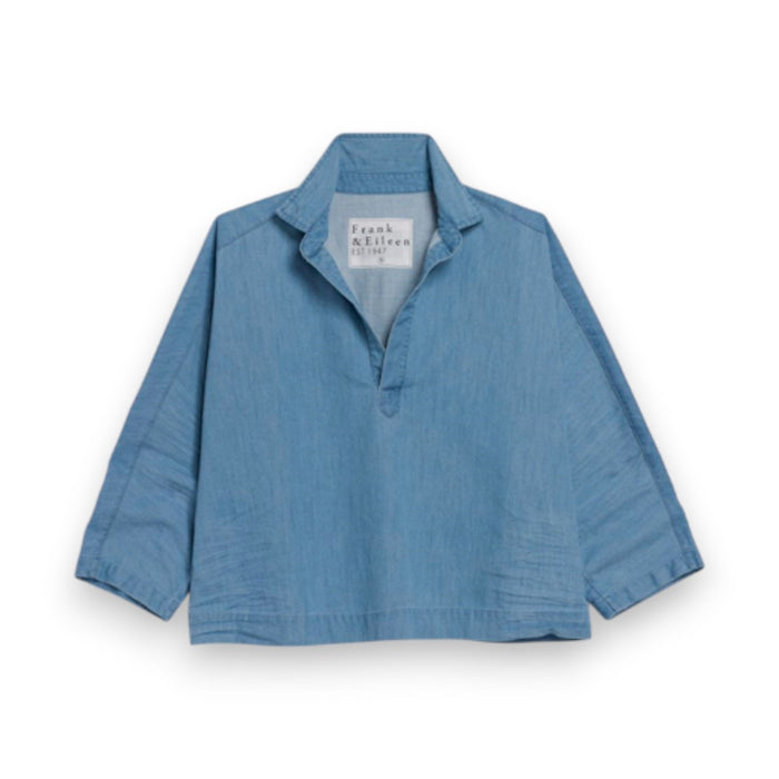 The FRANK & EILEEN Gabi Popover Shirt in Famous Denim Classic Blue features long sleeves, a collared V-neck, and a relaxed fit. Made from classic indigo denim, it is displayed on a white background.