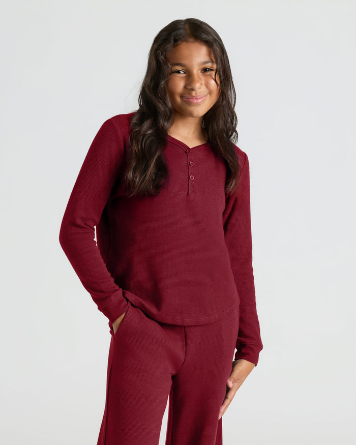 Girl in Girls Dark Maroon Waffle Long Sleeve Henley & Waffle Leg Pants, smiling.