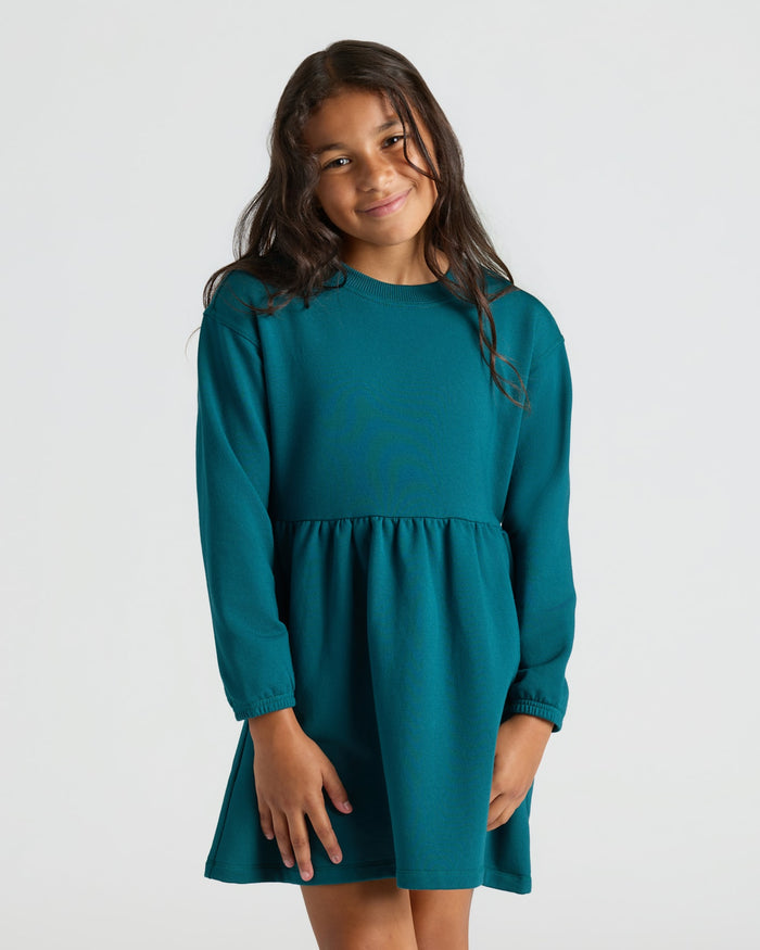 Girl in a teal fleece dress from Girls Dark Maroon & Deep Emerald Long Sleeve Fleece Dress 2-Pack.