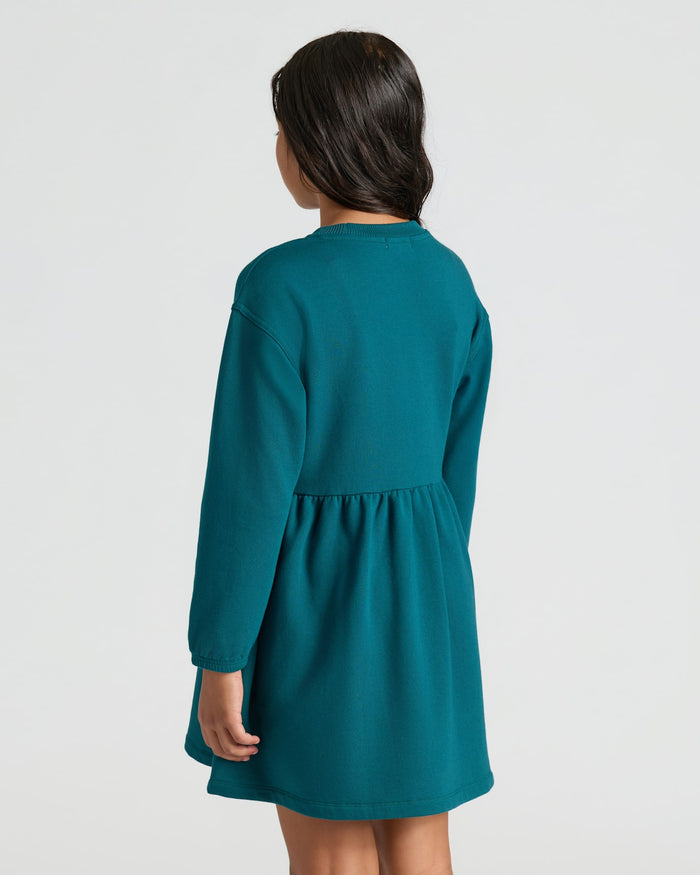 Girl wearing Girls Deep Emerald Long Sleeve Fleece Dress, back view.