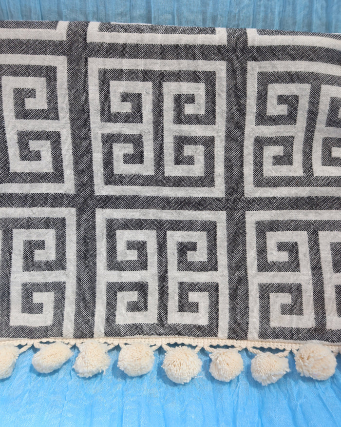 Black and cream/white greek key meander print clutch bag with pom pom trim and wet/dry water-resistant interior for the beach, made in Greece. Aelia Anna wet/dry bag