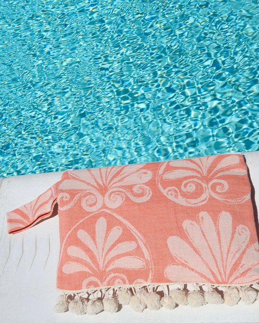 Coral floral print wet dry clutch bag with cream pom pom trim at the pool made in Greece. Greek brand Aeliea Anna wet dry beach bag water-resistant for summer and vacation