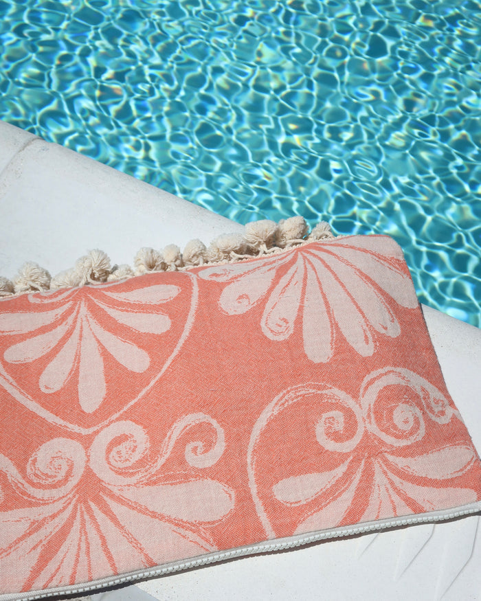 Coral floral print wet dry clutch bag with cream pom pom trim at the pool made in Greece. Greek brand Aeliea Anna wet dry beach bag water-resistant for summer and vacation