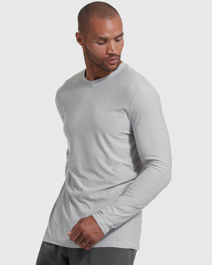 Man wearing Heather Light Gray Active Long Sleeve Crew T-Shirt against light background.