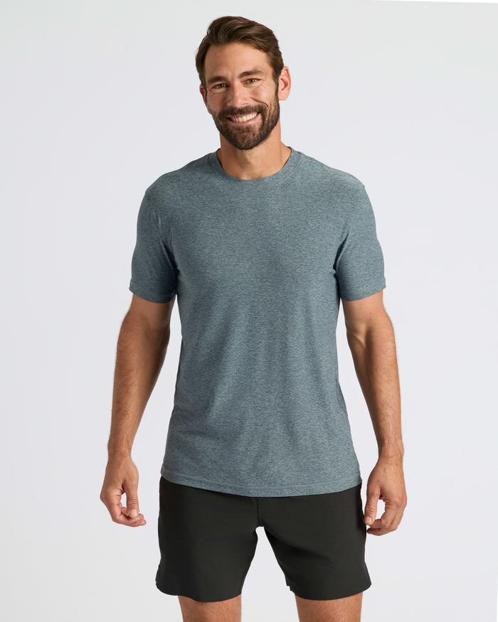 Man wearing Heather Navy Active Crew Neck Tee and black shorts, smiling.