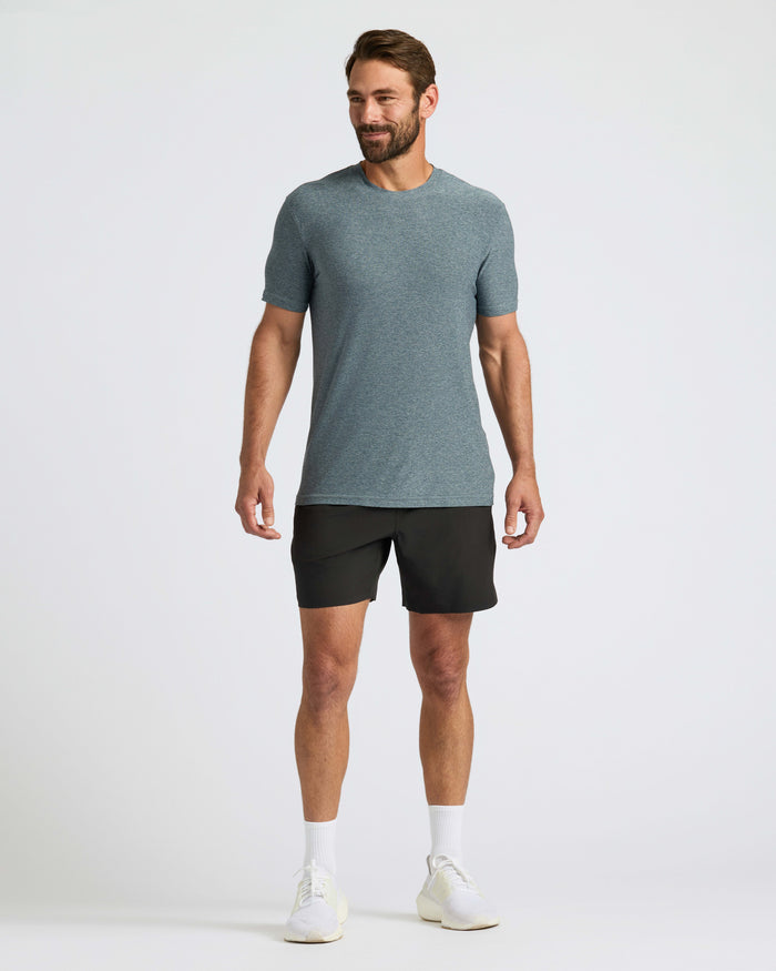 Man wearing Heather Navy Active Crew Neck Tee with athletic shorts and sneakers.
