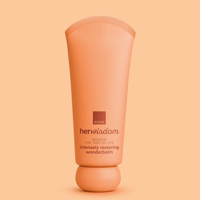 A squeeze tube of Avon Her Wisdom intensely Restoring Wonderbalm in a warm peach-orange color, centered against a matching solid peach background.