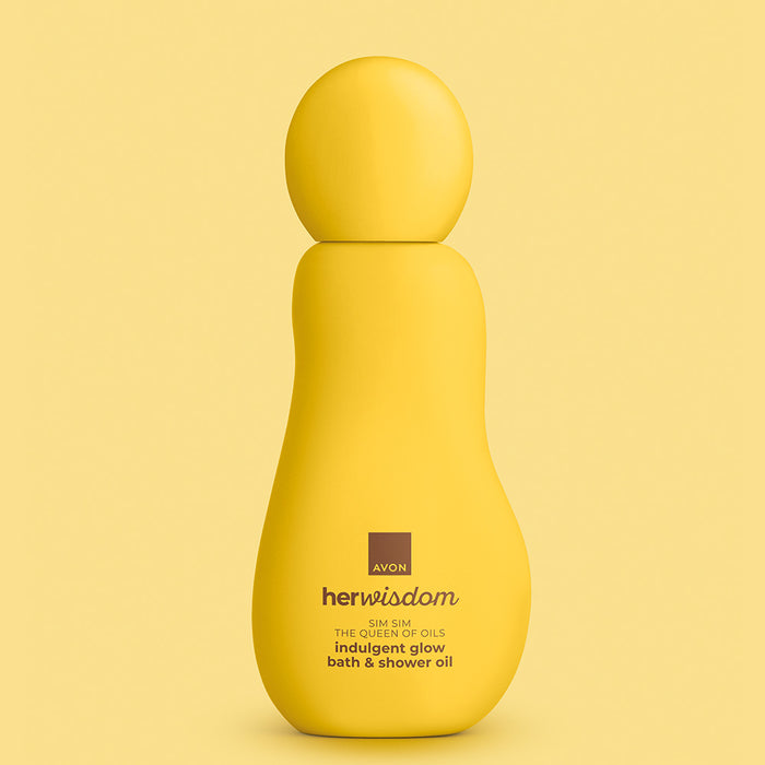 A yellow Avon Her Wisdom bottle of indulgent glow bath & shower oil, centered against a matching soft yellow background.