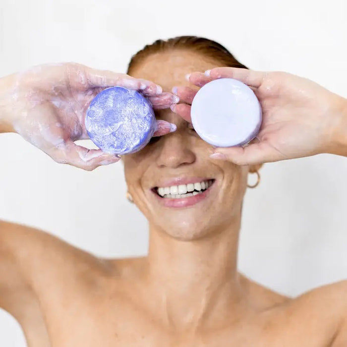A KITSCH Purple Toning Solid Conditioner Bar sits on its packaging, which states it's formulated with Biotin for blonde and highlighted hair, neutralizing brassiness. The labels affirm it's color safe, pH balanced, and vegan.