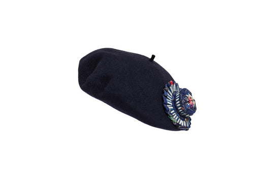 The LORNA MURRAY - THE AVENUE BERET is a dark blue Australian wool beret with a top stem and a vibrant embroidered floral patch on one side, shown on a plain white background.