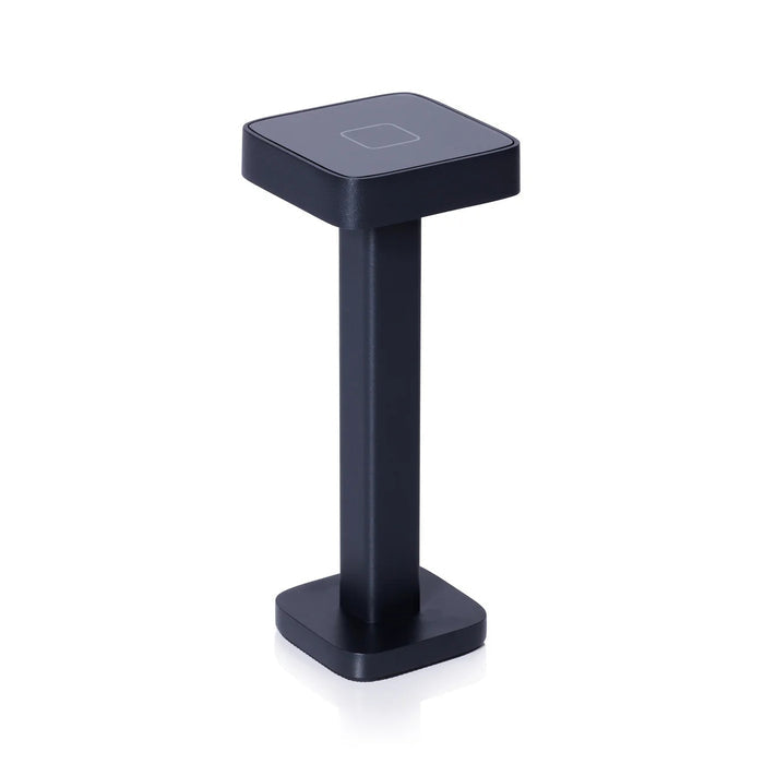 The ZODAX MONZA RECHARGEABLE TABLE LIGHT is a black, rectangular, pedestal-shaped device with a square touchpad on top, offering USB rechargeable capability and adjustable light intensity, shown upright on a white background.