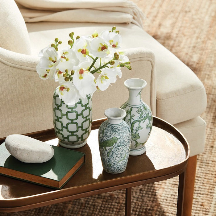 The NAPA HOME AND GARDEN - PHALAENOPSIS ORCHID STEM BUNDLE 6 features a bouquet of white orchids with pale pink centers and closed buds, tied with light brown twine. The realistic stems add elegance to home decor, beautifully arranged against a plain white background.