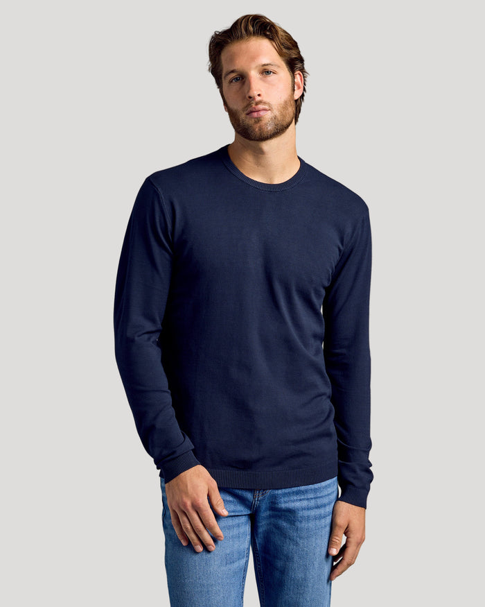 Man wearing Black & Navy Crew Neck Sweater 2-Pack with light-wash jeans.
