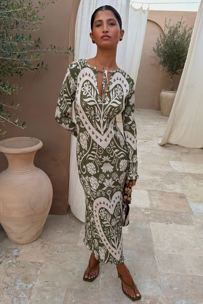 Olive Amara Plisse Gaia Dress featuring cream heart and floral motifs on green pleated fabric.