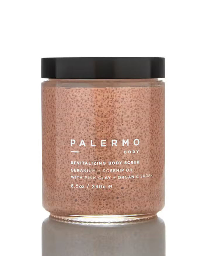 A clear jar with a black lid holds Palermo Body's Geranium and Rose Hip Body Scrub, made with geranium, rosehip oil, French pink clay, and organic sugar. Labeled 8.5 oz (240g).