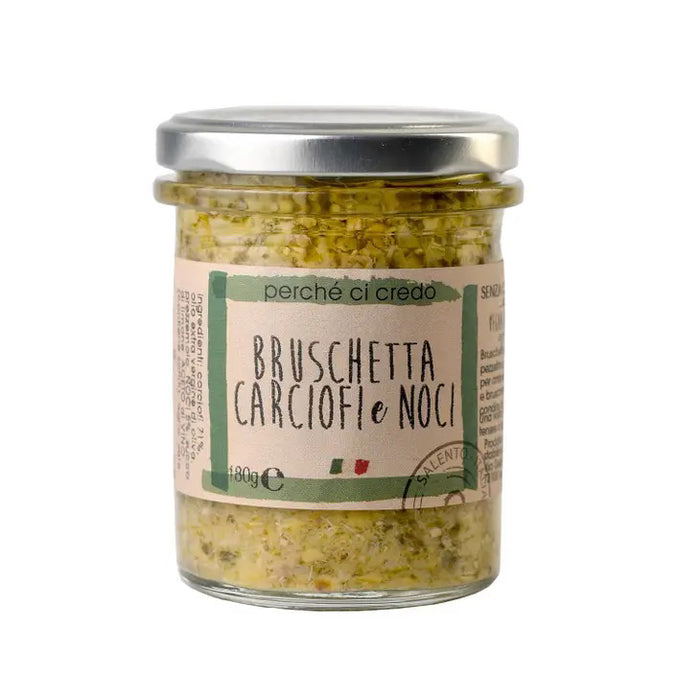 A glass jar with a silver lid containing "PERCHE CI CREDO - ARTICHOKE & WALNUT BRUSCHETTA," an exquisite Italian artichoke spread made by ZIA PIA IMPORTS. The light label features green and brown text, accented by the colors of the Italian flag. This delightful treat is perfect for fans of premium Italian foods.