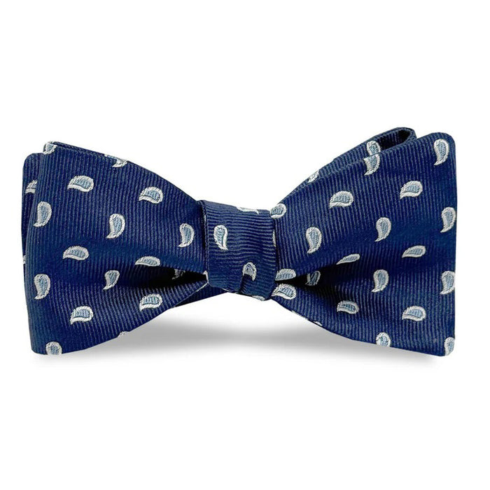 The BIRD DOG BAY PETER-BLAIR Cape Cod Silk Bow Tie in Navy features a white paisley pattern and comes unfastened for easy adjustment, offering elegance and comfort against a classic white background.