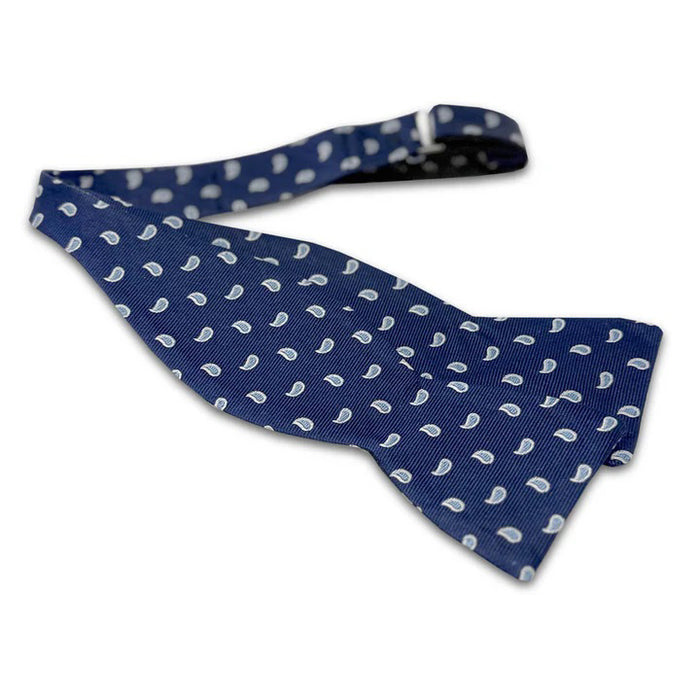 The BIRD DOG BAY PETER-BLAIR Cape Cod Silk Bow Tie in Navy features a white paisley pattern and comes unfastened for easy adjustment, offering elegance and comfort against a classic white background.