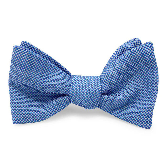 The PETER-BLAIR - ELBOW BEACH SILK BOW TIE IN BLUE by BIRD DOG BAY features a blue woven silk with a small white checkered pattern, adjustable neck, and is expertly crafted for timeless style.