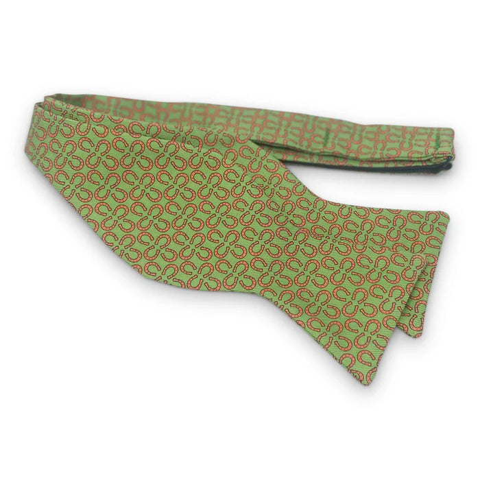 The BIRD DOG BAY PETER-BLAIR RINGERS Silk Bow Tie in green features a handmade design with small red horseshoes, an adjustable neck, and is displayed neatly tied against a white background.