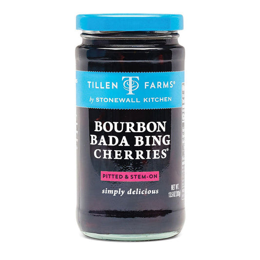 A jar of Stonewall Kitchen Bourbon Bada Bing Cherries. The label highlights these bourbon cocktail cherries are pitted and stem-on, and notes they are "simply delicious." The jar contains a net weight of 13.5 oz (383g).